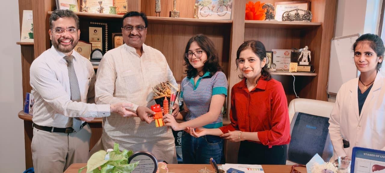Vrinda Tiwari presenting Arunarya's carved sensory pieces to Shri Dharam Singh Saini ji, with Dr. Rajiv Tiwari and Dr. Kshipra Dhawan Tiwari